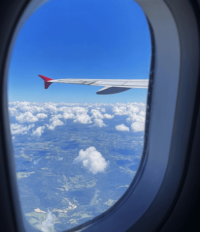 High-Altitude Flight Window View over Green Valleys